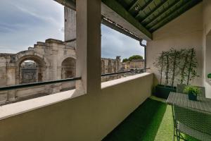 einen Balkon mit Blick auf die Ruinen eines Gebäudes in der Unterkunft Studio avec balcon donnant sur les Arènes d’Arles in Arles
