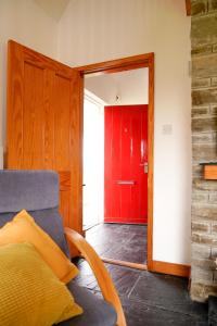 a living room with a red door and a couch at Butterfly Cottage in Achill