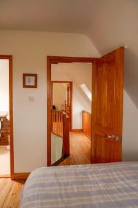 1 dormitorio con 1 cama y puerta de madera en Butterfly Cottage, en Achill
