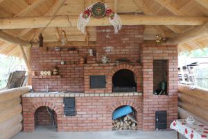 an outdoor brick oven with a wooden roof at Casa Andreia in Gura Humorului