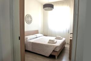 una camera da letto con un letto e asciugamani di Goccia Bianca - Gocce sul Mare a Savelletri