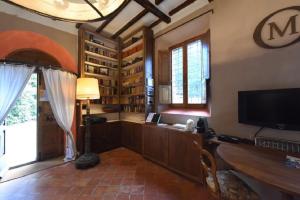 sala de estar con TV y escritorio con lámpara en MDQ - Azienda Agricola en Castiglione dʼOrcia