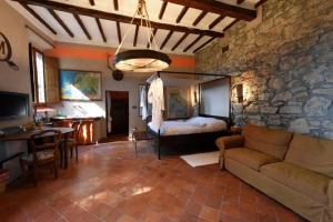 sala de estar con sofá y pared de piedra en MDQ - Azienda Agricola en Castiglione dʼOrcia