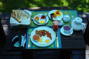 a table with a plate of breakfast food on it at Leaf Olu Ella in Yatiyantota