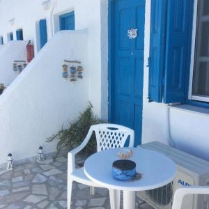 a white table and a white chair and a blue door at Ariadne Studios in Kalymnos