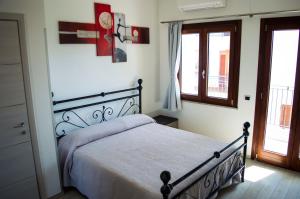 una camera con un letto in una stanza con finestre di Is Seddas B&B a Bari Sardo