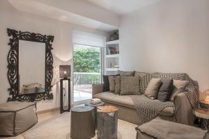 a living room with a couch and a mirror at Bliss Living in Vouliagmeni