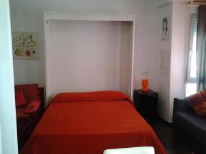 a bedroom with a red bed and a couch at Apartamento Estudio Linea de Playa in Vinaròs