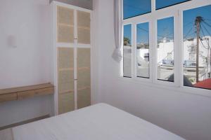 a white room with a bed and a window at M Residence Little Venice in Mikonos