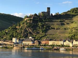 a castle on top of a hill next to the river at Kirchhausen in Oberwesel