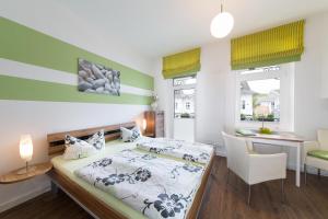 a bedroom with a bed and a table and a desk at Haus Zobler in Binz