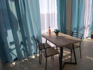 a dining room table with chairs and blue curtains at Blue Marine Ap 26 in Ravda