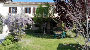 uma casa com glicínias roxas no quintal em San Rocco di Villa di Isola D'Asti em Asti