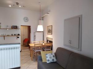 ein Wohnzimmer und eine Küche mit einem Sofa und einem Tisch in der Unterkunft Appartamento Vecchia Domo in Domodossola