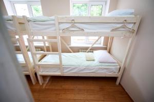 two bunk beds in a room with a window at Wanderlust Hostel in Almaty
