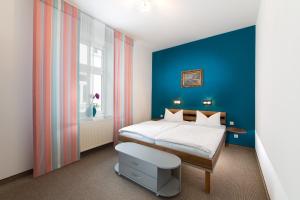 1 dormitorio con cama y pared azul en Haus Zobler, en Binz