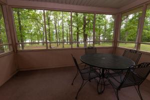 a screened in porch with a table and chairs at Kenlake State Resort Park in Aurora