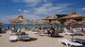 una playa con sillas y sombrillas y gente en ella en Вила Калиакра - Villa Kaliakra - 3 km to beach Bolata, en Balgarevo