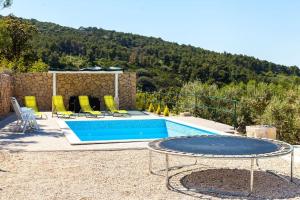 a swimming pool with a table and chairs next to it at House Sardelić in Prigradica