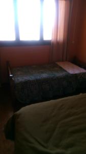 Hostal Panorámico في سان أنطونيو: غرفة نوم بسرير ونافذة مع ضوء الشمس