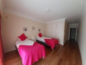 a bedroom with two beds with pink sheets at Vila Porto in Vila Nova de Gaia