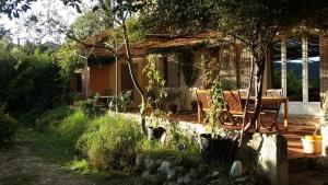 une maison dotée d'une terrasse couverte avec 2 chaises. dans l'établissement Les Oliviers, à Moustiers-Sainte-Marie