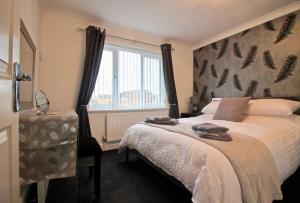 Un dormitorio con una cama grande y una ventana en Seascape, en Clacton-on-Sea