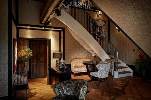een woonkamer met een trap en een tafel en stoelen bij Hotel TwentySeven - Small Luxury Hotels of the World in Amsterdam