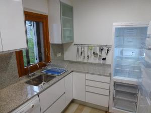 フォルミガルにあるApartamentos Formigal - admite mascotasの白いキッチン(シンク、冷蔵庫付)