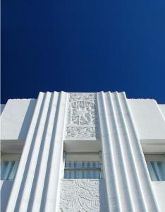 a tall white building with a blue sky in the background at The Savoy Hotel & Beach Club in Miami Beach