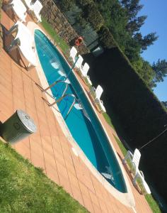 a large swimming pool with chairs at Casa Rural as Bentinas in Milladoiro