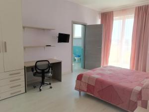 a bedroom with a bed and a desk and a chair at Stella Maris Casa per ferie sul mare in Anzio