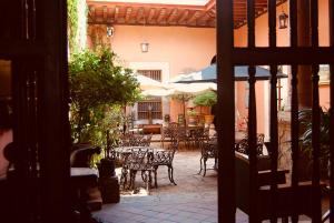 an outdoor patio with tables and chairs and umbrellas at Casa Eugenia Hotel in Morelia +88 photos