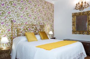 a bedroom with a large white bed with yellow pillows at La Chiocciolina in Lucca