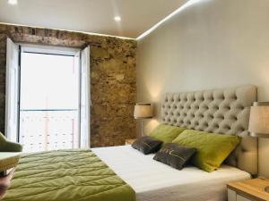 a bedroom with a large bed with a large window at Brand New Downtown Apartment in Lisbon