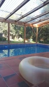 una piscina con una bañera blanca bajo un techo en "Dulces Sueños", en Cochabamba