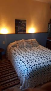 een slaapkamer met een bed met een blauw en wit dekbed bij "Dulces Sueños" in Cochabamba