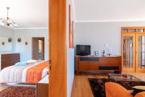 Un dormitorio con una cama y un escritorio con televisión. en Apartment Laranjeiras, en Calheta
