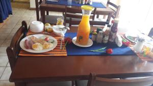 a table with a plate of food and a bottle of orange juice at Diphororo guest house in Mogwase