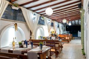 a restaurant with wooden tables and chairs and windows at hotel Yanis in Lozenets