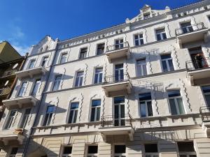 a large white building with windows and balconies at Próchnika 49 Rooms in Łódź