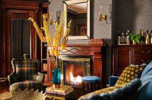 a living room with a fireplace and a chair at The Cliffside Inn in Newport