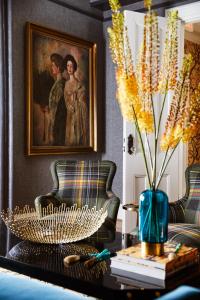 a living room with a couch and a table with a vase at The Cliffside Inn in Newport