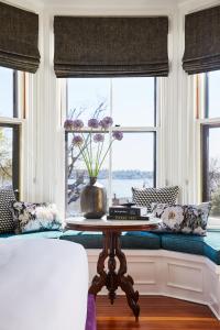 a living room with a table in front of a window at The Cliffside Inn in Newport