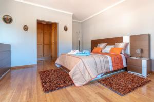1 dormitorio con 1 cama y 2 alfombras en Apartment Laranjeiras, en Calheta