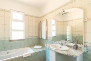 Un baño con lavabo, bañera y espejo. en Apartment Laranjeiras, en Calheta 29 fotos más