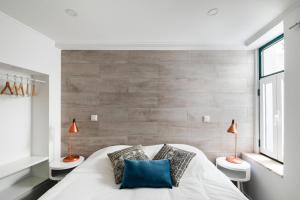 a bedroom with a white bed with two lamps on two tables at PRINCIPE REAL Apartments in Lisbon