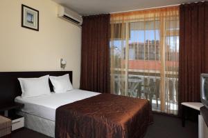 a hotel room with a bed and a window at hotel Yanis in Lozenets