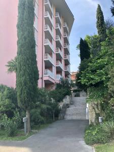 波爾托羅的住宿－Room 211 - Aparthotel Jadranka，粉红色的公寓楼前面设有楼梯