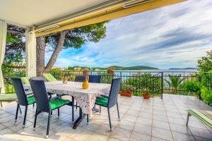 a table and chairs on a patio with a view of the water at Apartments Lidija in Rogoznica